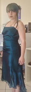 [Justine CM] Portrait de moi avec mes cheveux bleus-verts (turquoise), attachés en chignon et retenus par un pic à cheveux. Frange et une mèche de cheveux à gauche encadrent mon visage. Fard à paupières et rouge à lèvres violets. Pendentif en forme de papillon bleu-vert. Je porte une longue robe sirène couleur bleu canard.