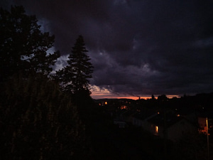[Justine CM] Photo prise su 4ème étage d'un crépuscule très nuageux, sombre, avec une bande rose orangée au loin.