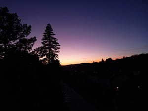 [Justine CM] Crépuscule, où l'on voit le ciel avec des teintes douces allant de l'orange au loin, puis vers le rose, puis vers le violet et le bleu nuit.