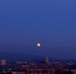 [Justine CM] Pleine lune orangée sur un ciel bleu foncé.
